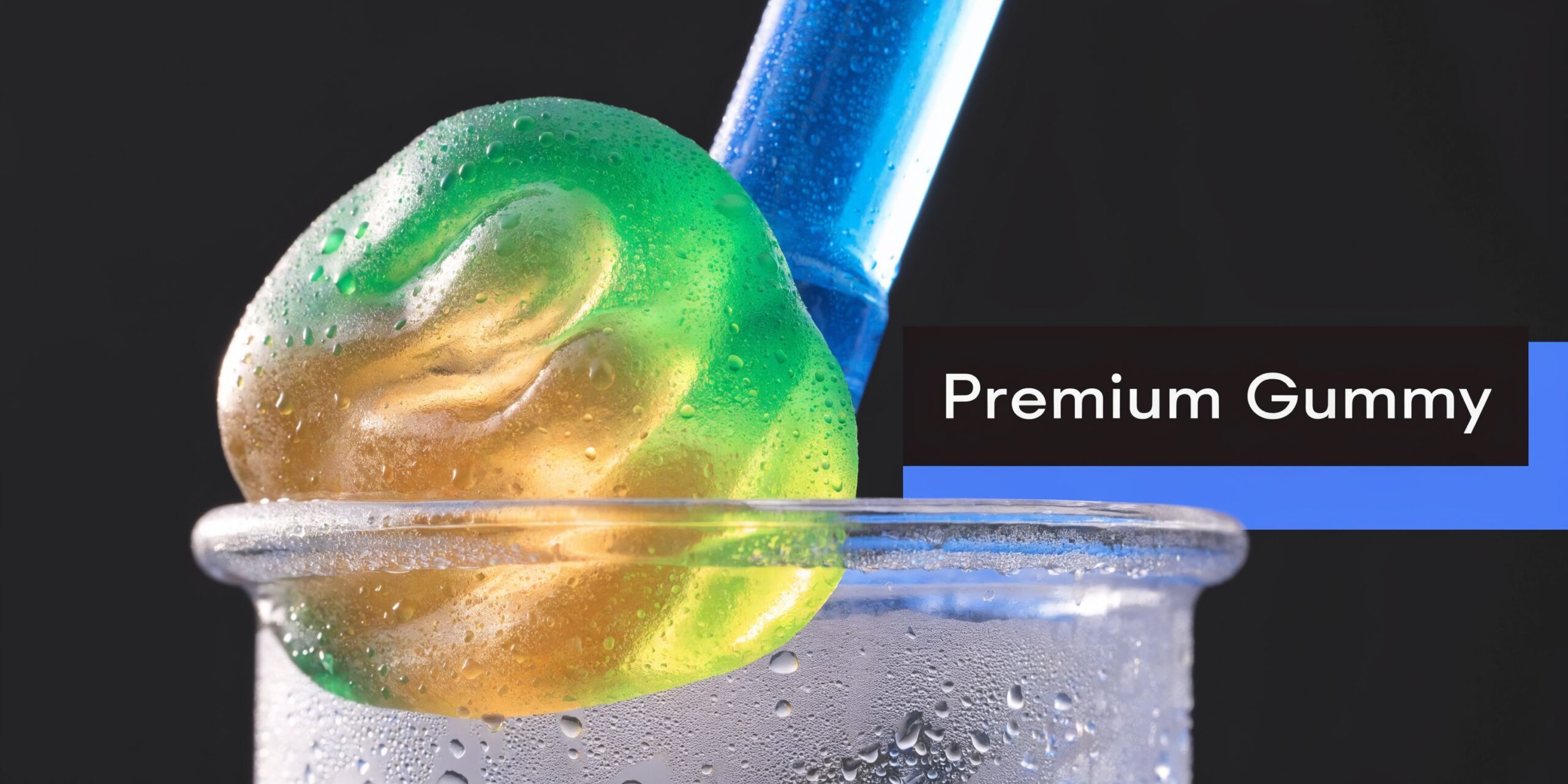 A vibrant green and orange gummy placed inside a frosted glass beaker with a blue light background.