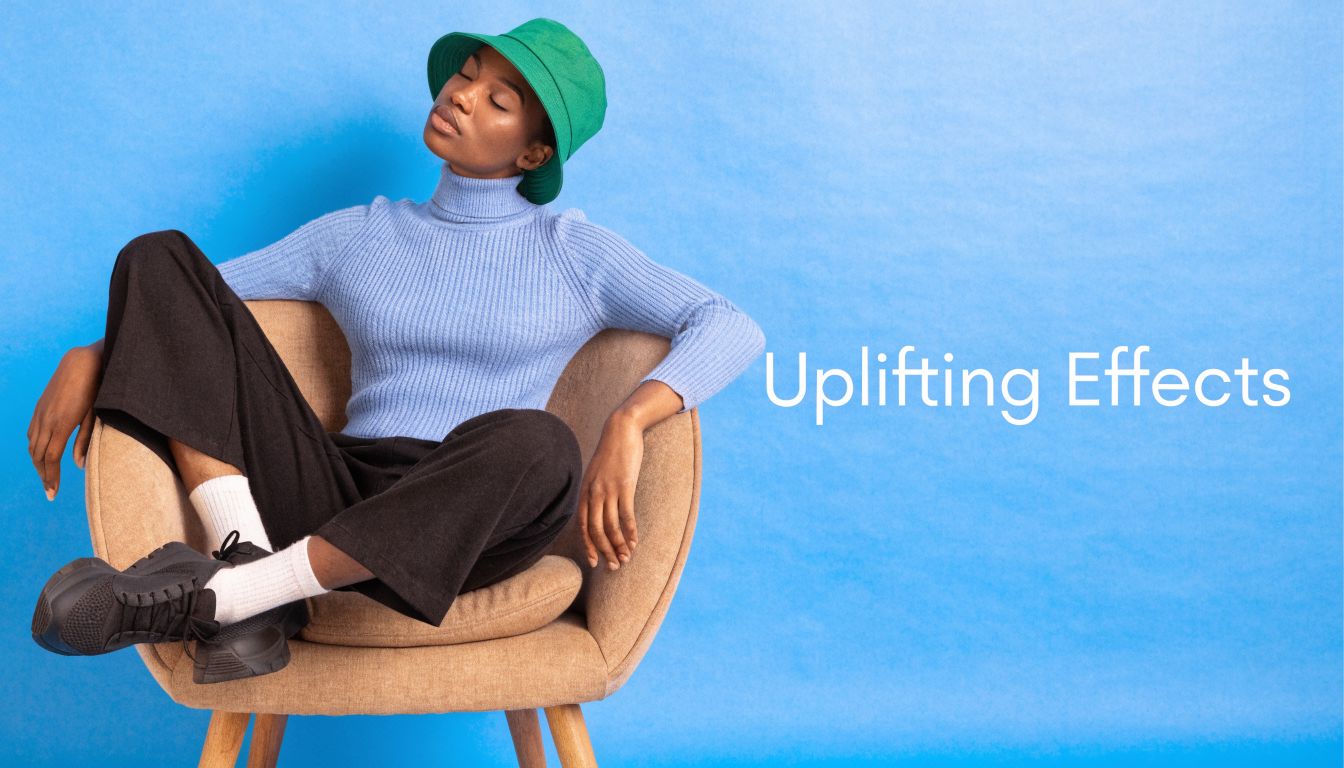 A relaxed woman wearing a green bucket hat and blue sweater sitting in a chair.
