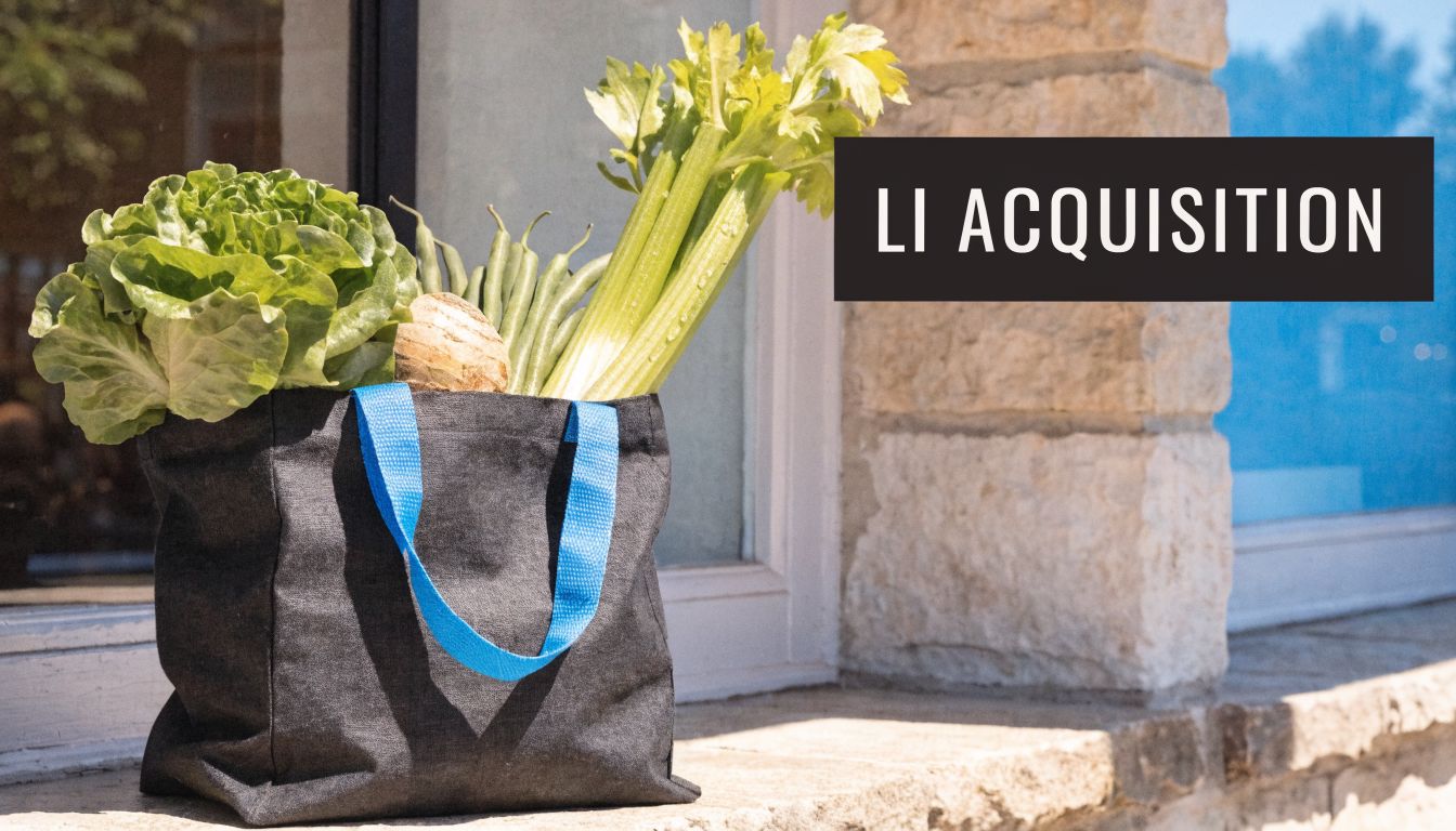 A reusable fabric shopping bag filled with fresh celery, green beans, and lettuce on a ledge.