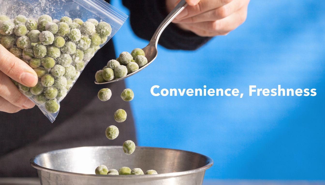 A hand pouring frozen green peas from a plastic bag onto a metal spoon into a bowl.